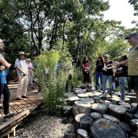 Andrew “Birch” Kemp, executive director of Arboretum Detroit, addresses tour attendees from the “stumpscape” inside Circle Forest, one of the organization’s latest native restoration projects in Detroit’s East Ferry Warren neighborhood. 