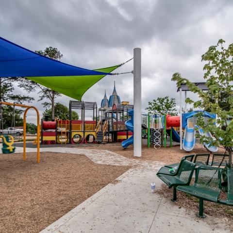 Renovated playground in Medal of Honor Park, featuring benches, shade spots and recently planted trees