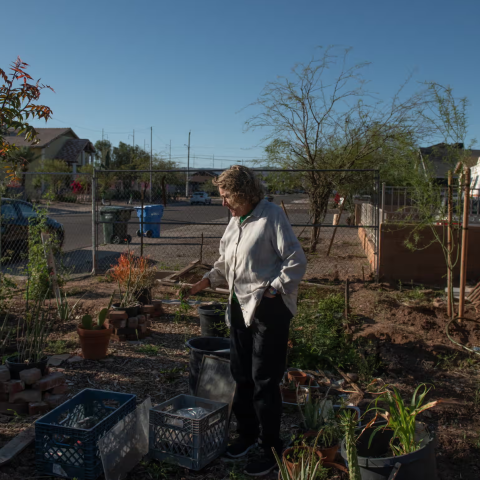 A photo of a resident of the Grant Park Neighborhood standing next to the newly planted tree. 